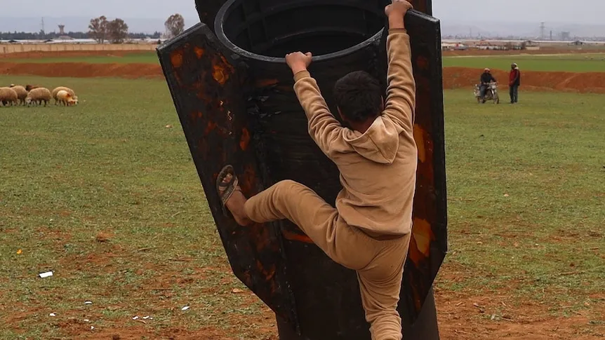 Verifying Viral Photo: Child Climbs Real Missile Booster in Syria